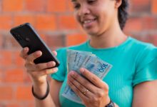 Mulher meia idade com dinheiro na mão.