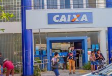 Pessoas em frente ao banco Caixa.