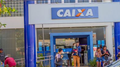 Pessoas em frente ao banco Caixa.