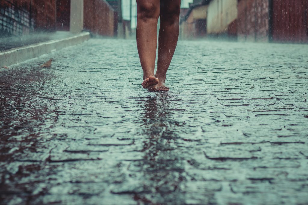 Mulher andando na chuva. 