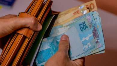 Mulher guardando dinheiro na carteira.