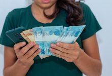 Mulher ganhando dinheiro com celular.