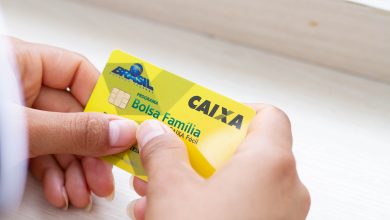 Mulher segurando o Bolsa Família.