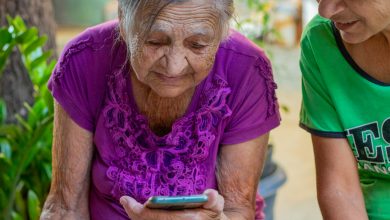 Duas senhoras de idade mexendo no celular.